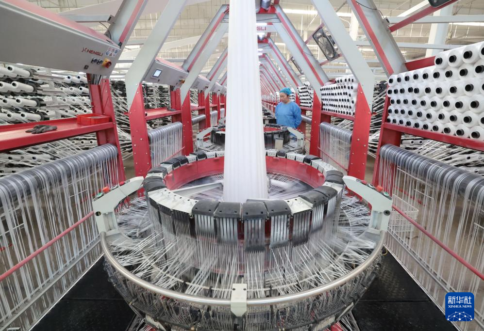 7月18日,工人在河北省行唐县一家包装袋企业的生产车间工作。