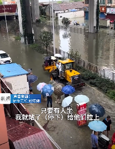 暴雨致路面积水 铲车司机免费搭载行人