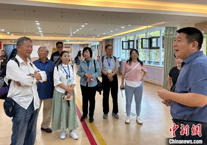 左一为王金城，他正在和兰州一家社区养老中心负责人交流。丁思　摄