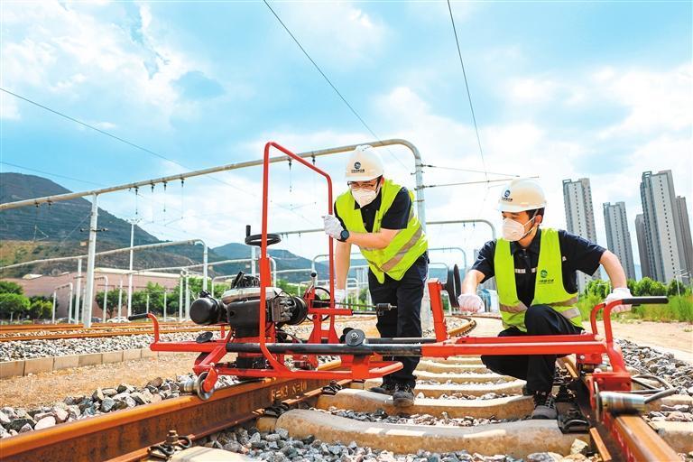 兰州轨道交通设施部工建中心工程师冒着酷暑打磨钢轨，保障列车安全运行。