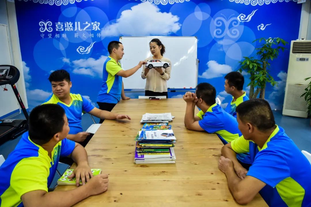 2015年8月13日，深圳市喜憨儿洗车中心的负责人黄艳（中）指导员工确定自己的工作范围。新华社记者 毛思倩 摄