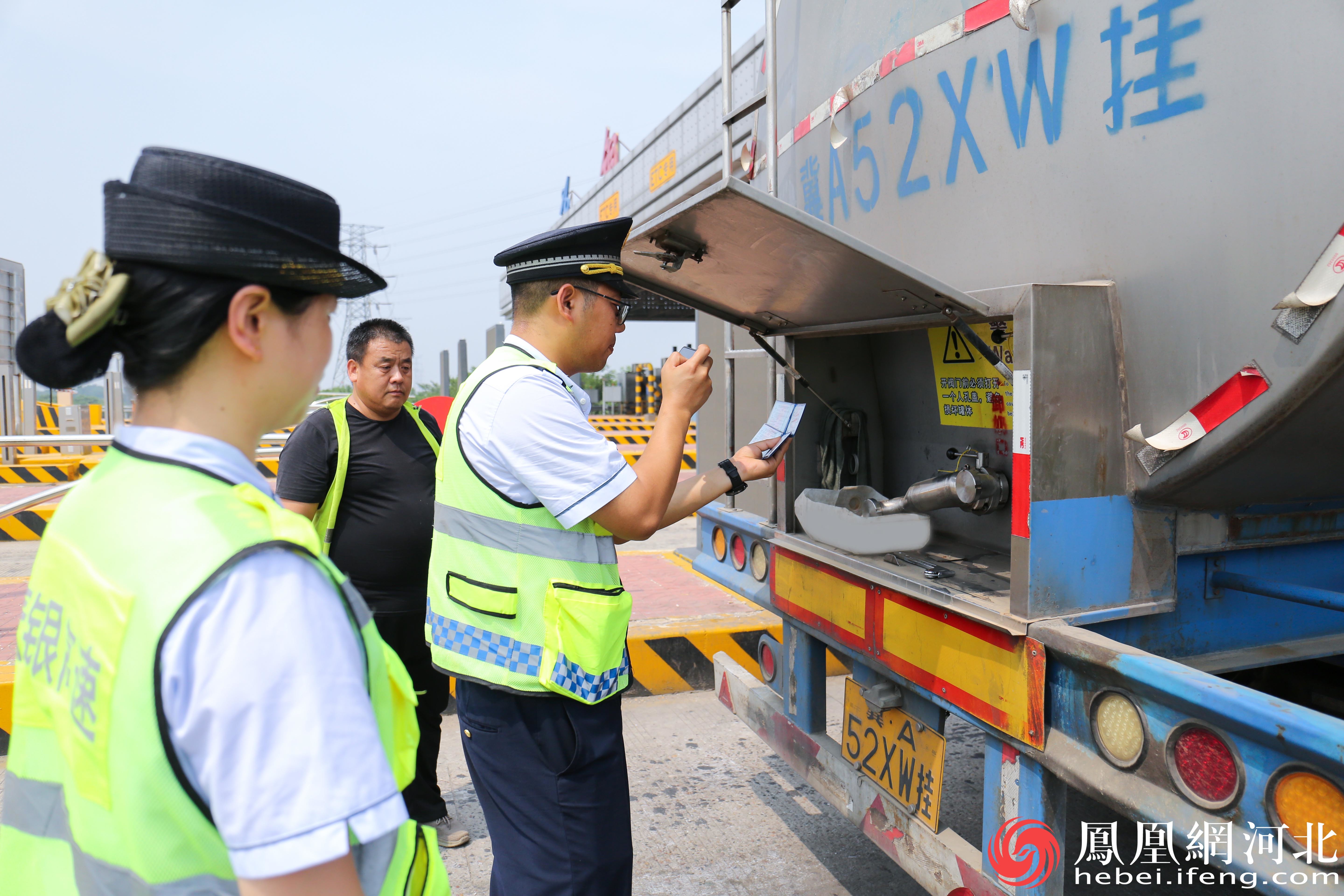 高速工作人员正严格对过往的运输车辆进行细致检查，确保道路安全与交通秩序。