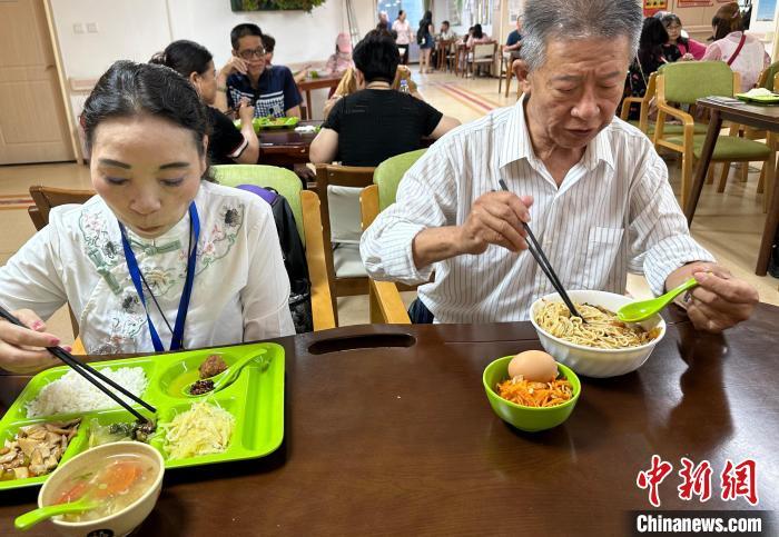 图为王金城(右)和陈习珍(左)在兰州一家社区养老中心用午餐　丁思　摄