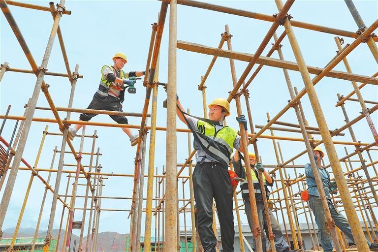 在积石山县大河家镇灾后恢复重建集中安置点，工人正在烈日下施工。