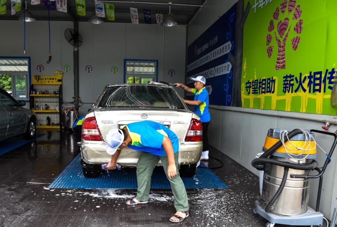 2015年8月13日，深圳喜憨儿洗车中心的员工在洗车。新华社记者 毛思倩 摄