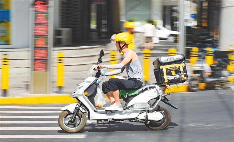 外卖小哥穿街过巷，为市民配送外卖。
