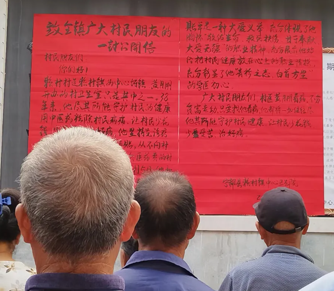 村民驻足观看《致全镇广大村民朋友的一封公开信》。