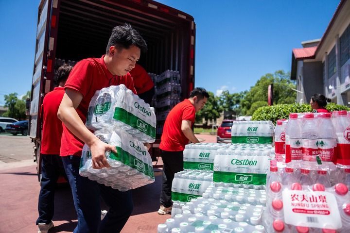 7月30日，在湖南湘潭县河口中学安置点，志愿者搬运生活物资。新华社记者 陈思汗 摄