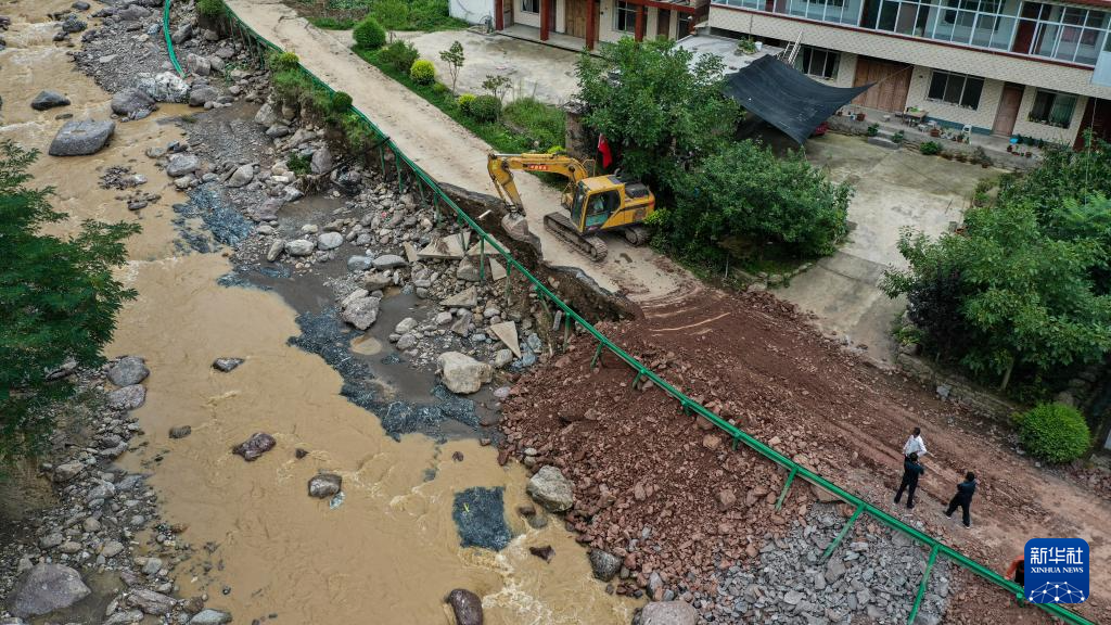 7月28日，在陇南市武都区佛崖镇王沟村，当地抢险救援人员在抢修受损农村公路（无人机照片）。