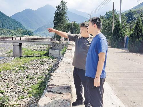 7月26日，郝立杰（左）和白雪林在巡河。本报记者 王 营摄