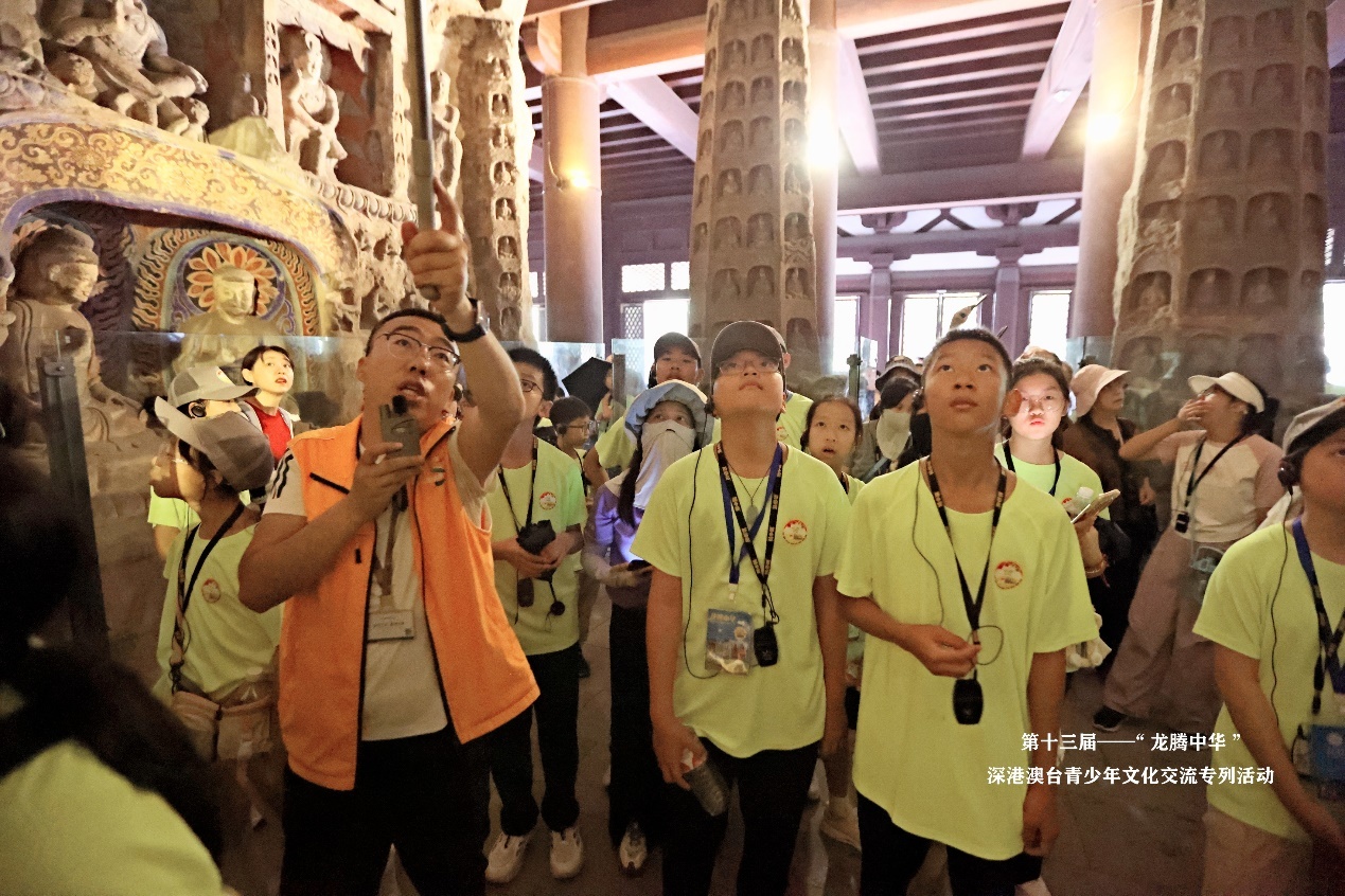 图：同学们认真聆听讲解员介绍云冈石窟