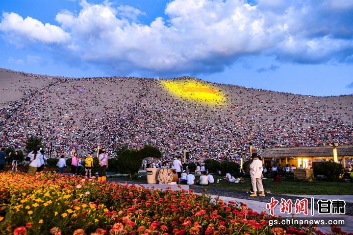 图为敦煌鸣沙山上，上万名搭客静待万东说念主星空演唱会开幕。王斌银 摄