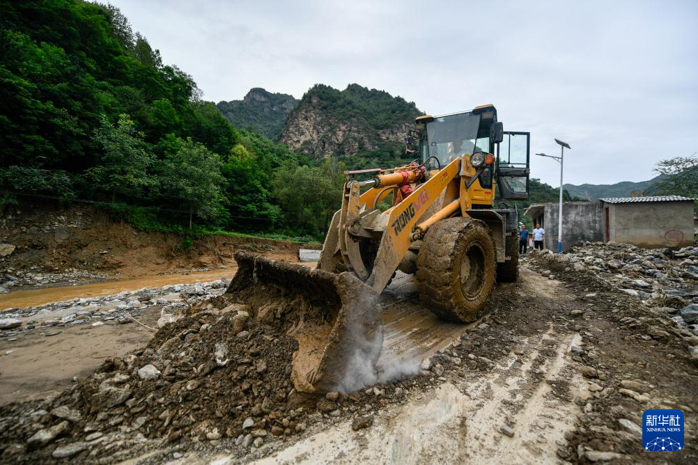 7月28日，在陇南市武都区黄坪镇成坝村，当地抢险救援人员在抢修受损农村公路。