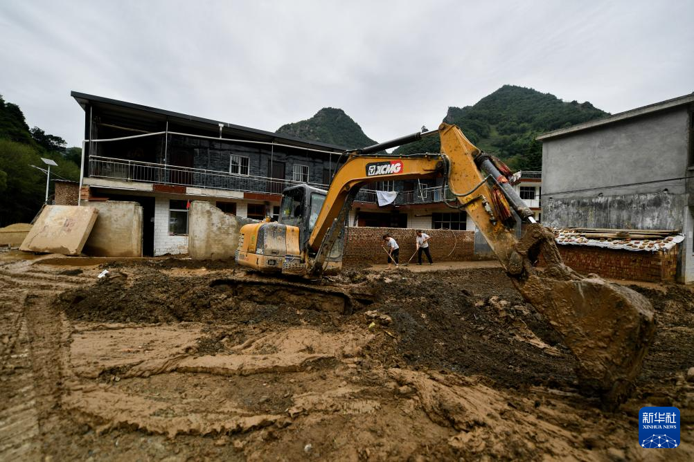 7月28日，在陇南市武都区黄坪镇成坝村，当地抢险救援人员在操作机械清理淤泥。
