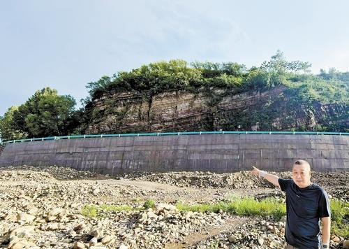 7月31日，涉县交通运输局工作人员介绍河茅线乡道小会村段新修建的片石混凝土路基挡墙。 本报通讯员 张达安摄