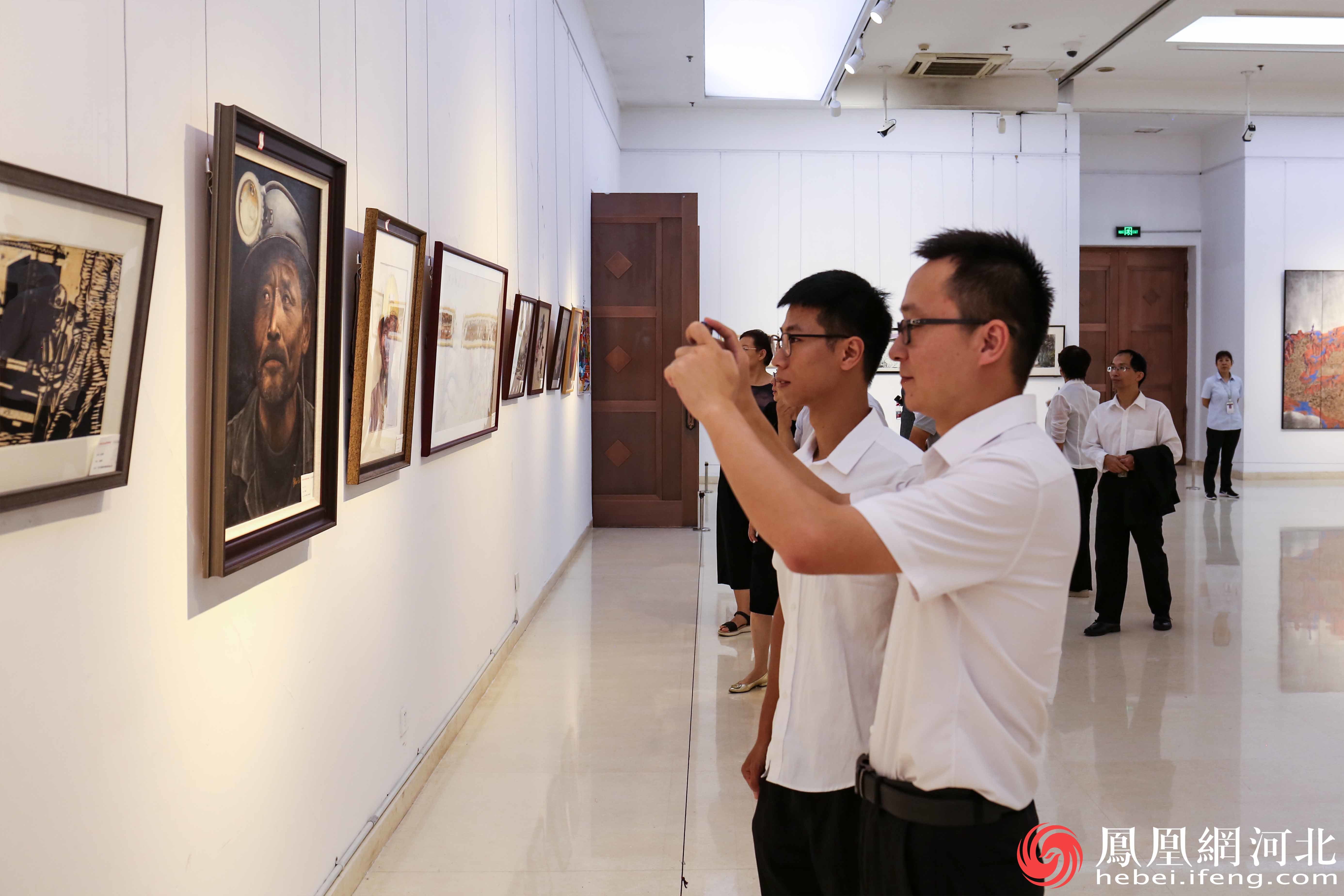 参观者正用手机记录下这些生动的作品。