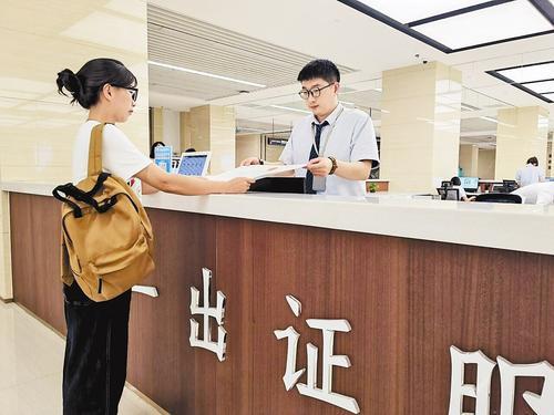 8月6日,天津肯德基有限公司保定地区工作人员李芳芳(左)在提交办证申请当天就领到了新开门店的食品经营许可证。本报记者 李连成摄