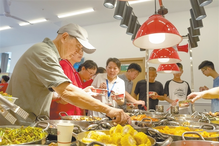 在南昌高新区御水园社区幸福食堂，居住周边的老人正在食堂餐台打菜。