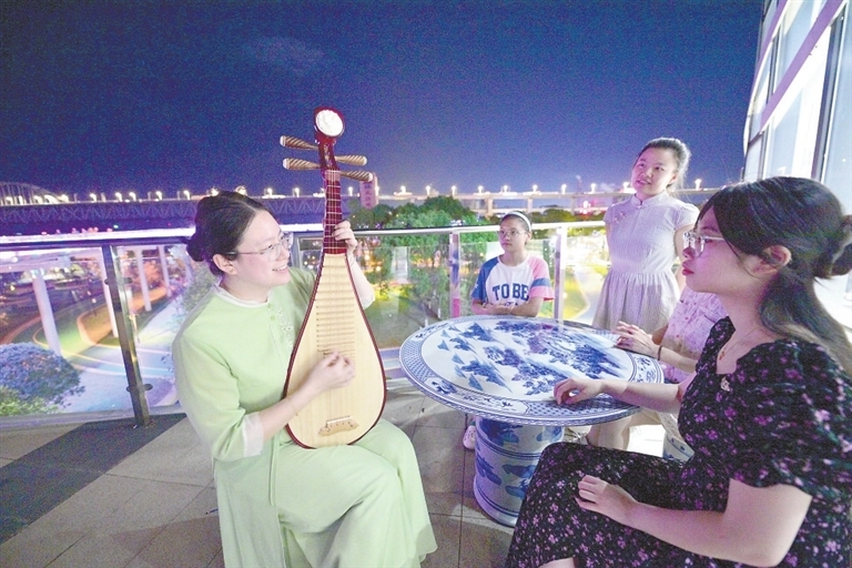 7月30日，市民在长江国家文化公园九江城区段的璀璨夜色中弹奏琵琶，交流技艺。