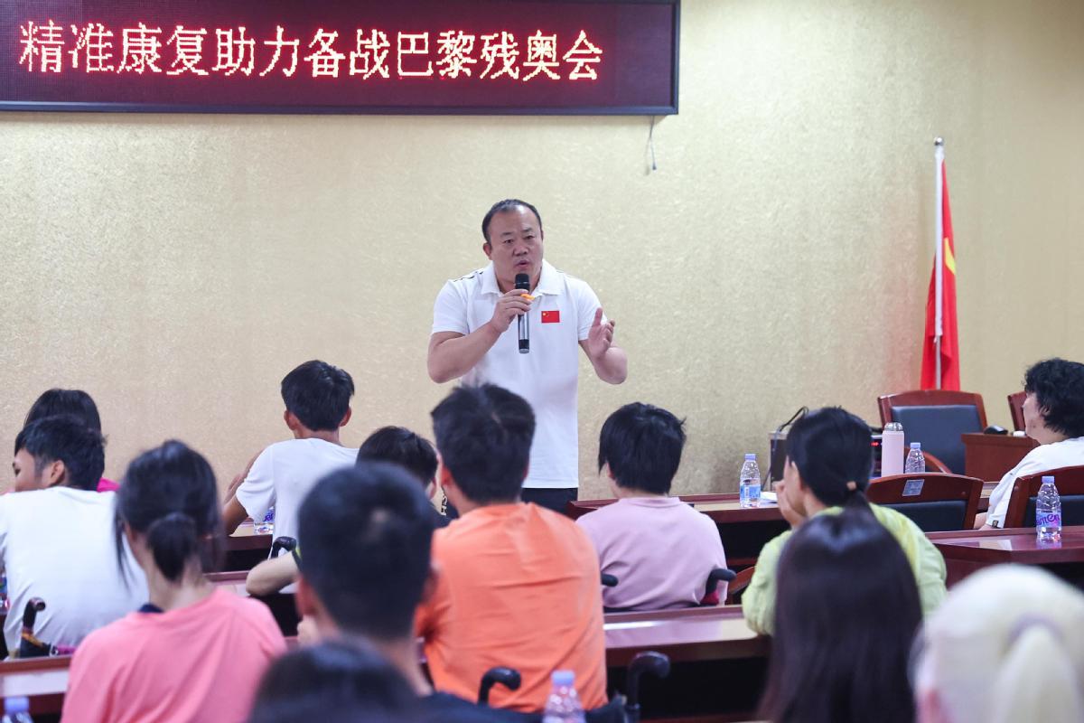 教练正在为备战巴黎残奥会的运动员打气