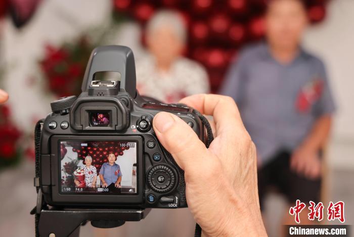 8月9日，在山东省临沂市兰山区银雀山街道银城社区，摄影师在为一对金婚夫妇拍摄金婚照。许传宝 摄