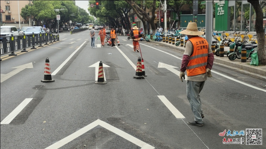 工作人员正在对南京西路非机动车道标线进行施划