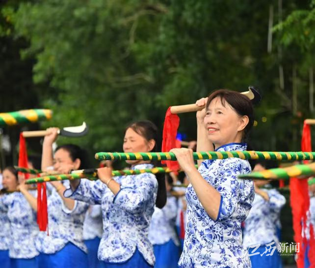 ▲居民群众在广场上表演禾杠舞