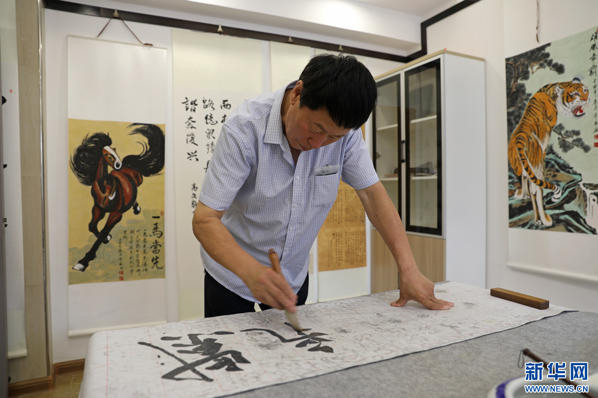 8月21日，丽水社区书画小组的刘立秋老人在书画室练习书法。新华网 魏会博 摄