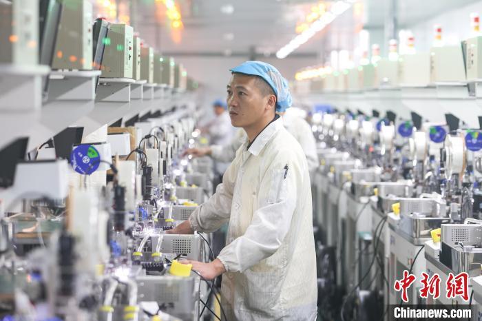 图为江西吉安市一家公司制造车间内,工作人员在设备旁作业。(资料图)刘力鑫 摄