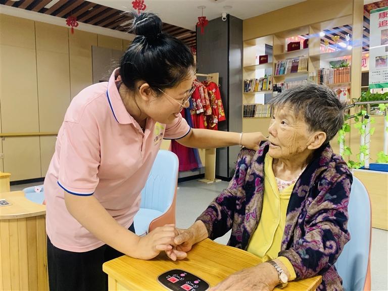西园街道综合养老服务中心内，护理人员指导老人做理疗。