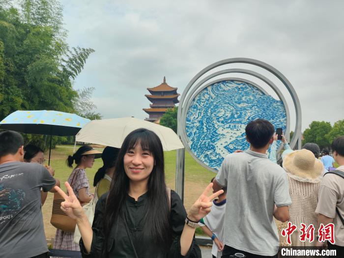 8月22日，日本友城青少年江西访问团成员在景德镇陶阳里历史文化街区龙珠阁前一块创意青花瓷片旁拍照留影。姬甜梦 摄