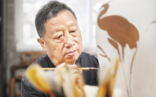 7月13日，刘立忠聚精会神地装饰着他心爱的瓷器。