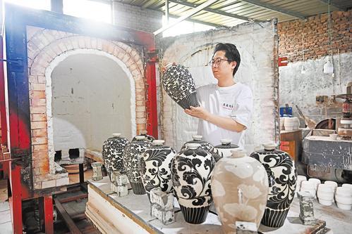 7月13日，90后磁州窑“守艺人”张鹏宇在开窑后仔细查看瓷瓶烧制效果。