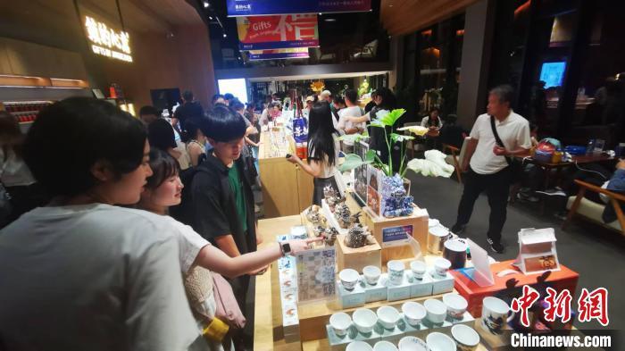 8月21日晚，日本青少年在景德镇陶溪川文创街区一家陶瓷文创店挑选商品。中新社记者 　姜涛 摄
