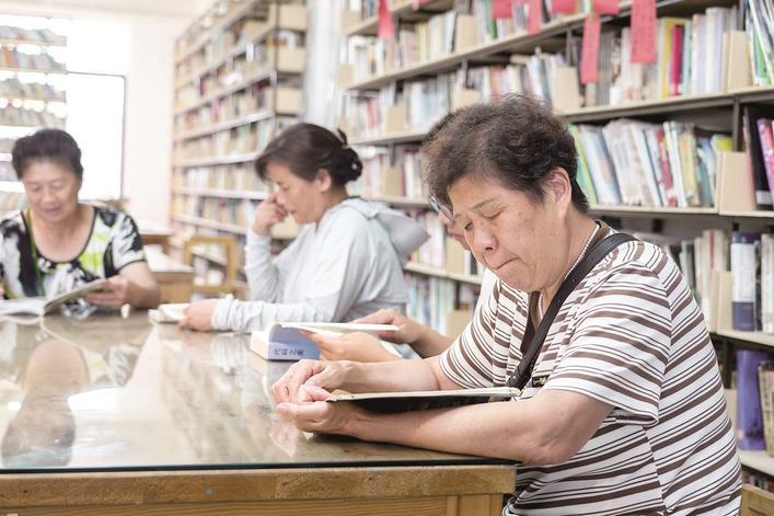 村民在馆内翻阅图书，消磨午后时光