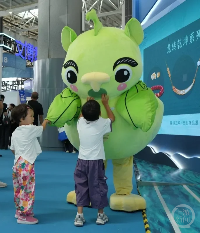 孩子们争相和青铜鸟形尊人偶合影