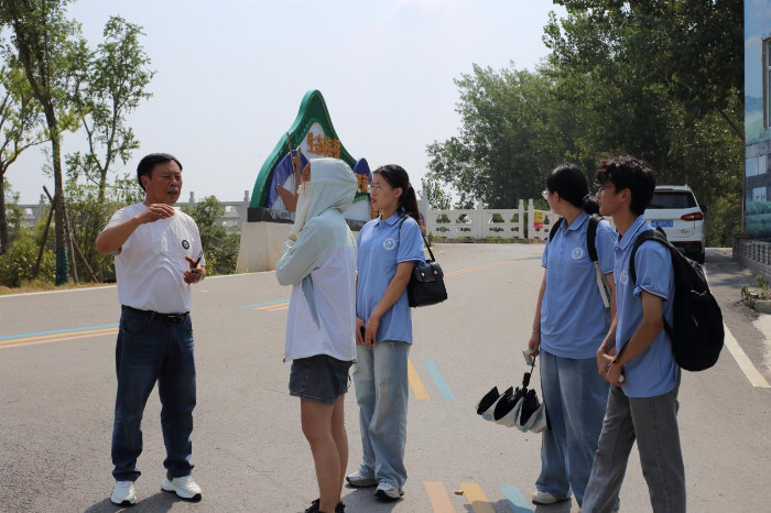 （图为刘传前书记在为电视台记者和团队成员介绍淝南村如何实现生态与经济共发展 李祥尔摄）