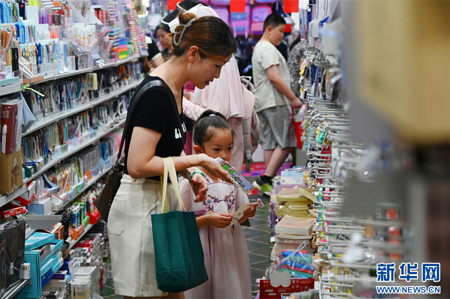 8月25日，河南省开封市一家文具店内，学生和家长在挑选文具。