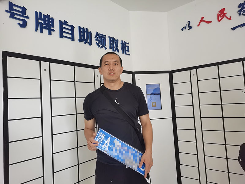 ▲市民张先生在南昌市车管所号牌自动领取区像取快递一样领取到了机动车车牌。