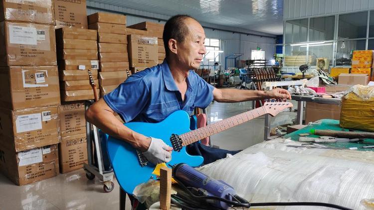 昌乐鄌郚镇，工人正在调试电吉他。都亚男摄