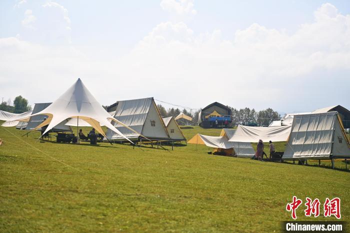 近日，在甘肃省临夏回族自治州康乐县打门村溪水谷露营基地内，游人享受休闲时光。中新社记者　李亚龙　摄