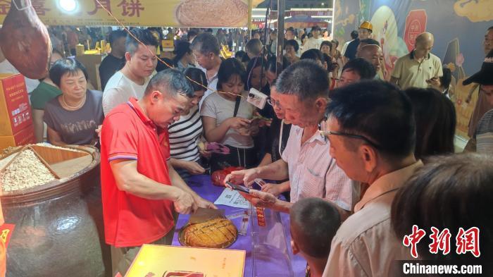 市民在化州月饼文化节展销区现场品尝月饼。梁天宇 摄