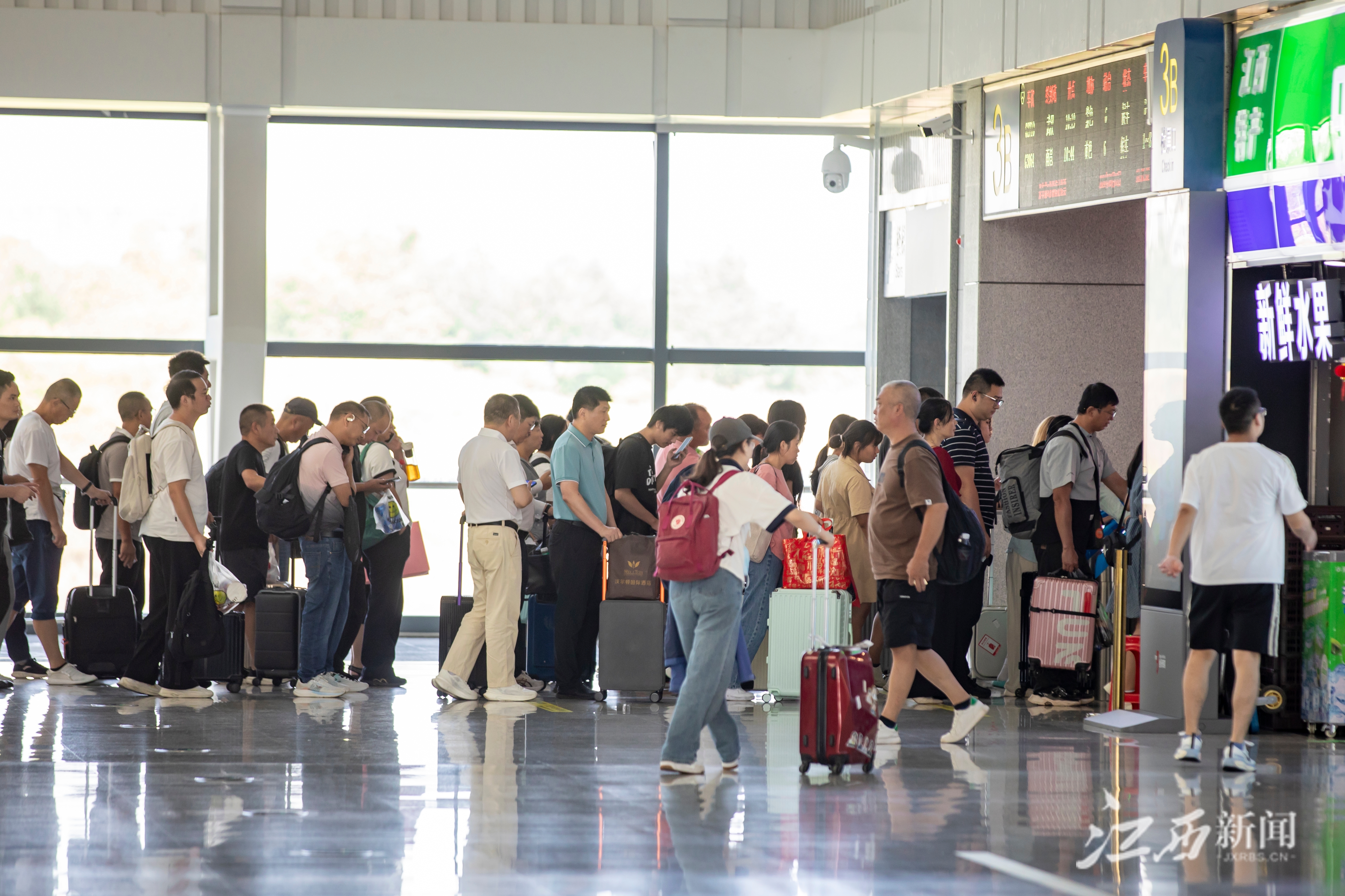 ▲赣州西站旅客有序排队验证进站乘车。摄影丨邹阳