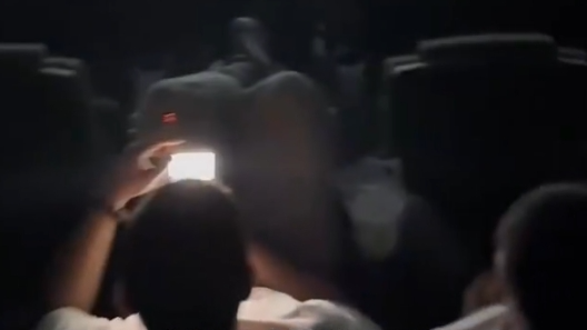 两男子影院抽烟聊天、脚踩座椅，一场电影下来共抽了8根烟