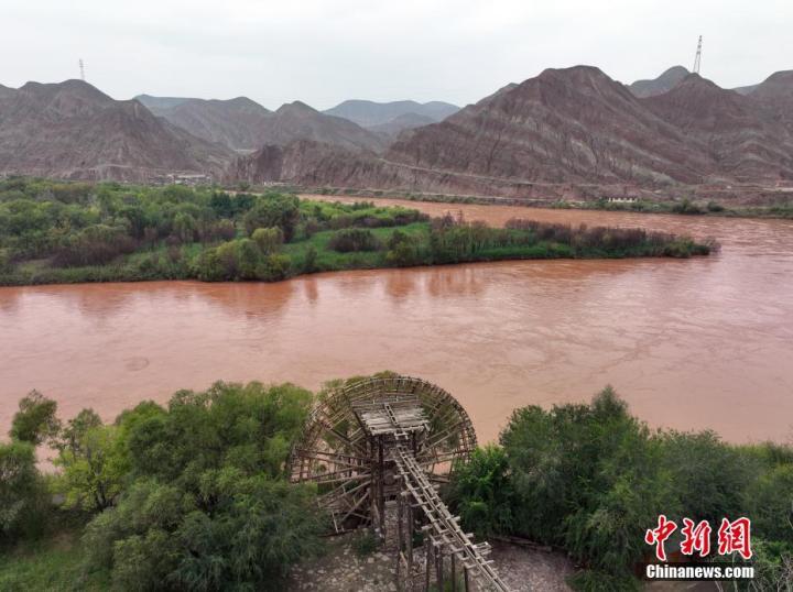 9月11日，无人机航拍甘肃省兰州市西固区新城镇三百多年的大水车与岸边的水墨丹霞地貌。中新社记者　毛建军　摄