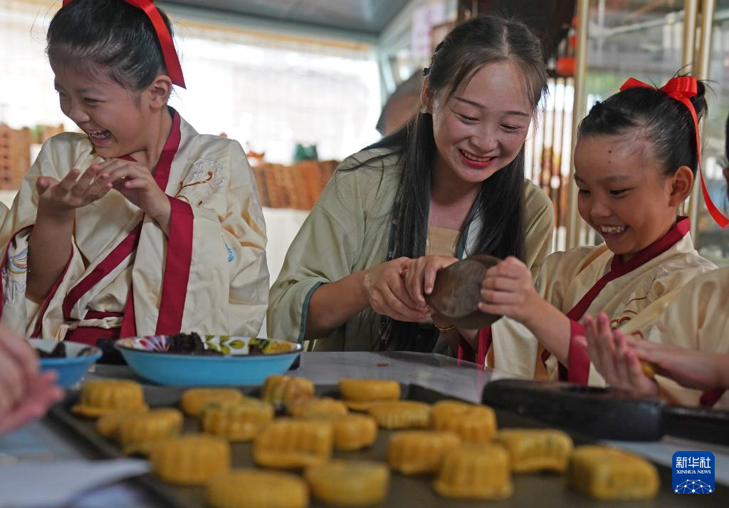 9月11日，孩子们在老师（中）的指导下体验传统手工月饼制作。