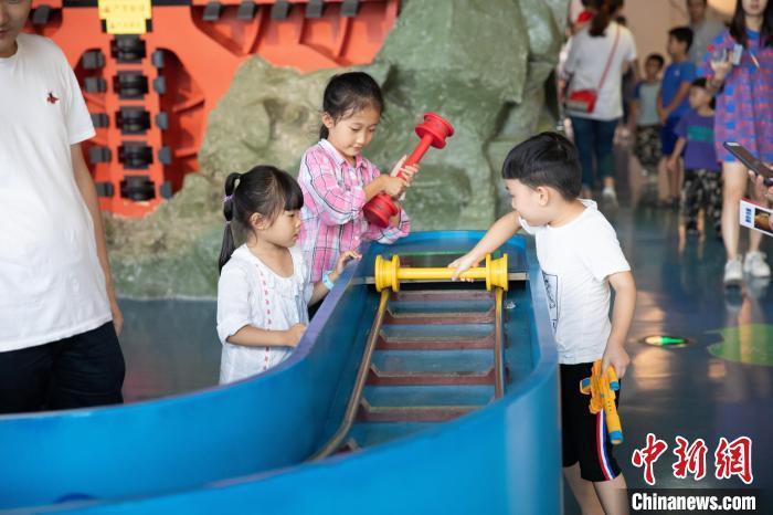 图为孩子们在重庆科技馆内感受科学魅力。重庆科技馆供图