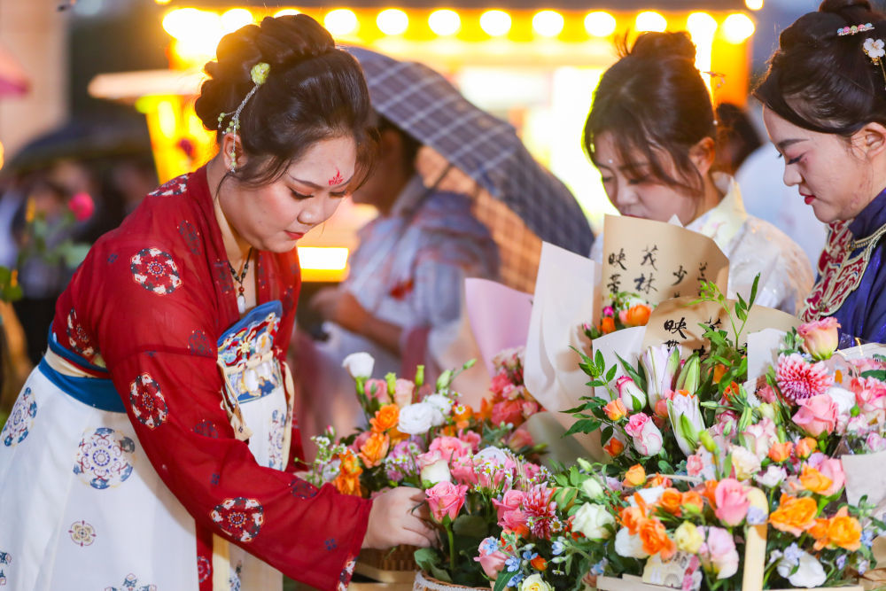 9月13日，在兰州市雁滩公园，身着汉服的青年志愿者展示插花技艺。新华社记者　郎兵兵　摄