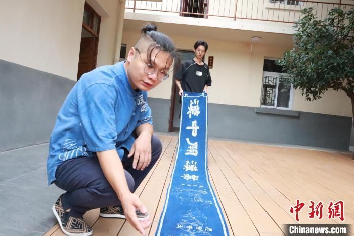 2024年9月，李鹏伟(左)与邵华(右)共同展示蜡染长卷。　李一璠 摄
