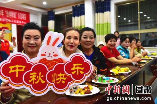 图为兰州客运段列车员为出行旅客送上中秋祝福。